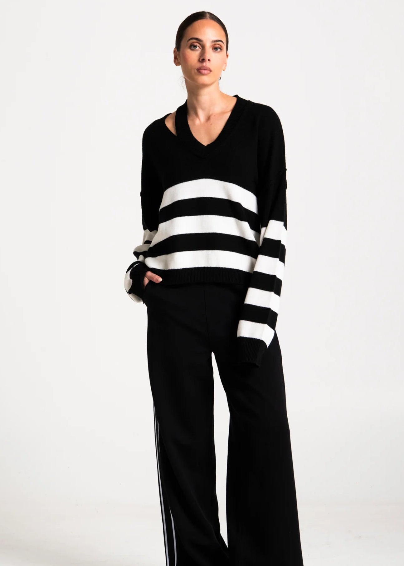 Woman wearing black and white stripe jumper on white background