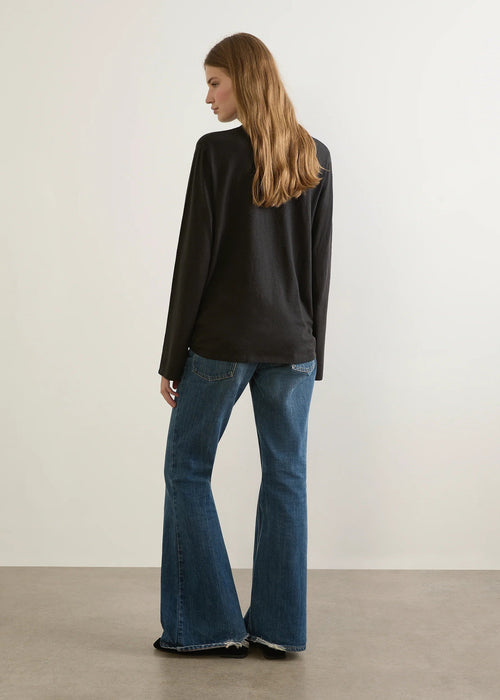 Person wearing a black t-shirt with a graphic and text, against a plain background.
