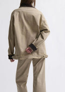 Woman wearing a beige jacket on white background