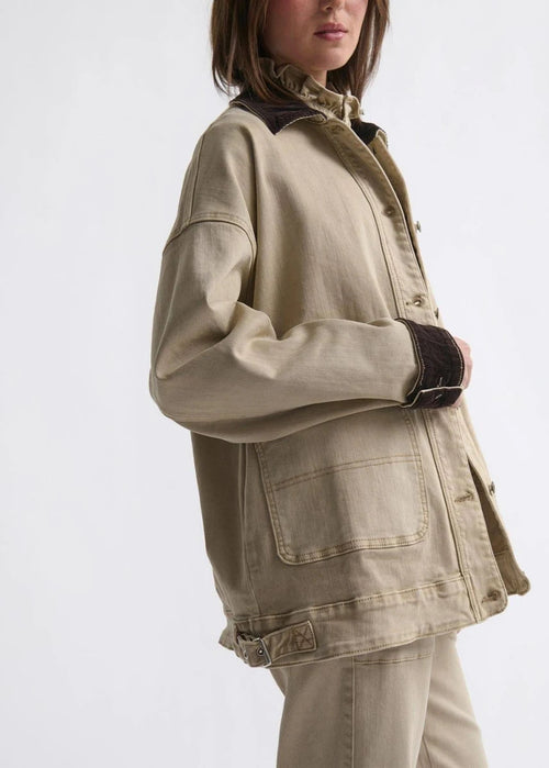 Woman wearing a beige jacket on white background