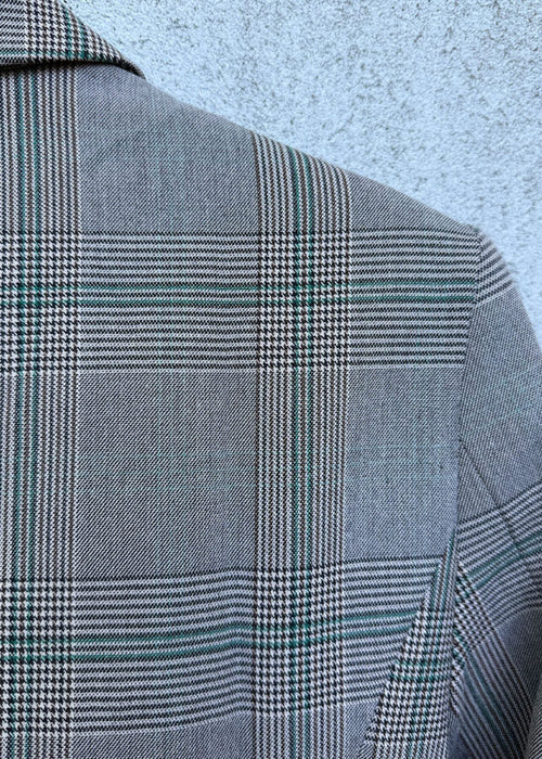 Gray checkered jacket on a textured light blue background
