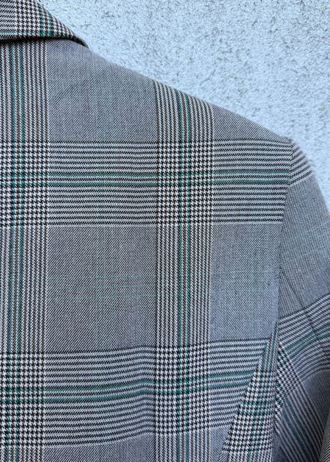 Gray checkered jacket on a textured light blue background