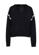 Black sweater with white embellishments on a white background