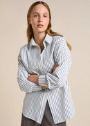 Woman wearing a striped shirt against a beige background