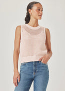 Woman wearing a light pink sleeveless knitted top and blue jeans on a plain background