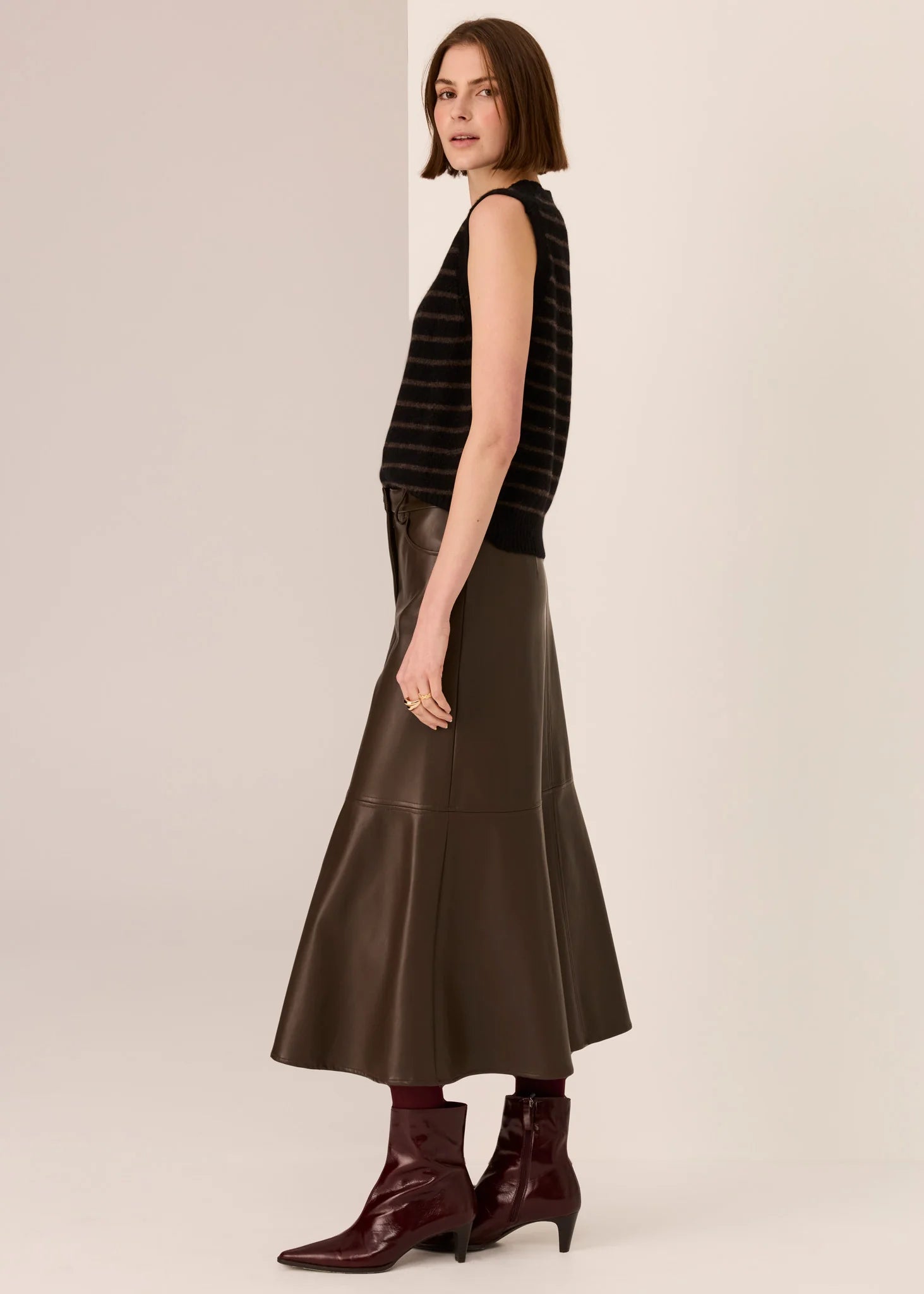 Woman wearing a black sleeveless top  on a beige background