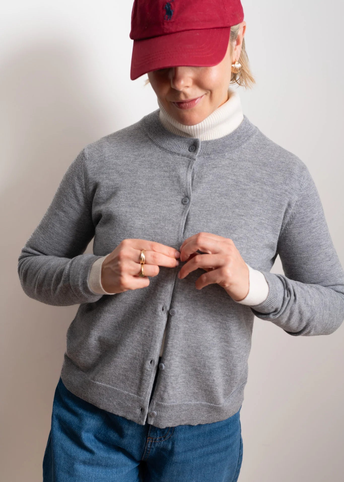 Woman wearing a grey cardigan on a white background