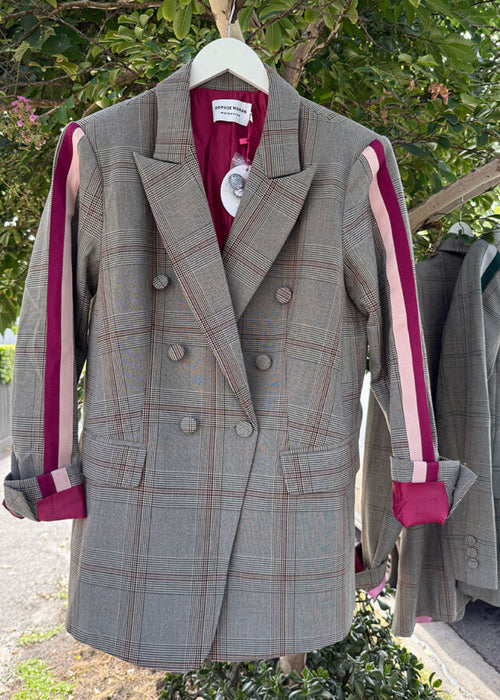 Gray plaid coat with pink accents hanging outdoors