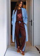 Woman wearing brown track pants in doorway