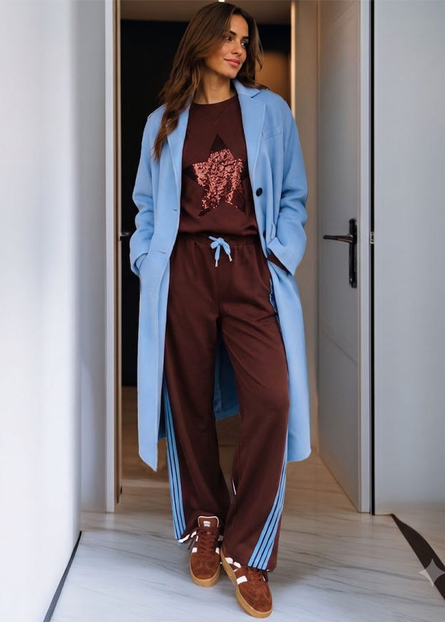 Woman wearing brown track pants in doorway