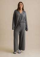 Woman wearing a grey loungewear set on a beige background