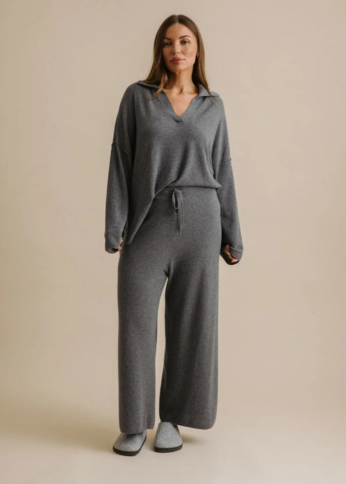 Woman wearing a grey loungewear set on a beige background