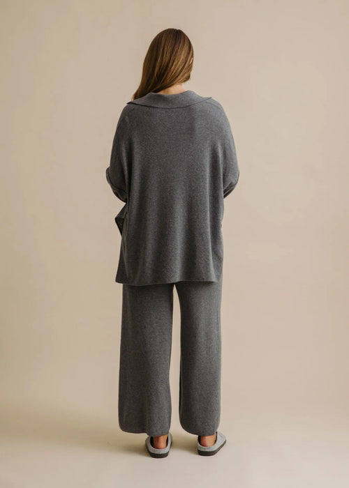 Woman wearing a grey loungewear set on a beige background