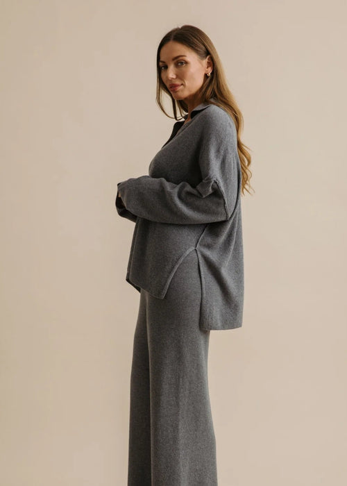 Woman wearing a grey loungewear set on a beige background