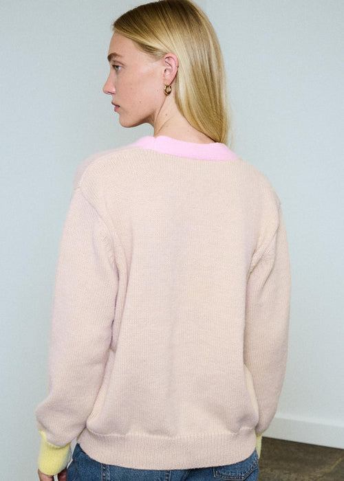 Woman wearing multi colour cardigan on blue background