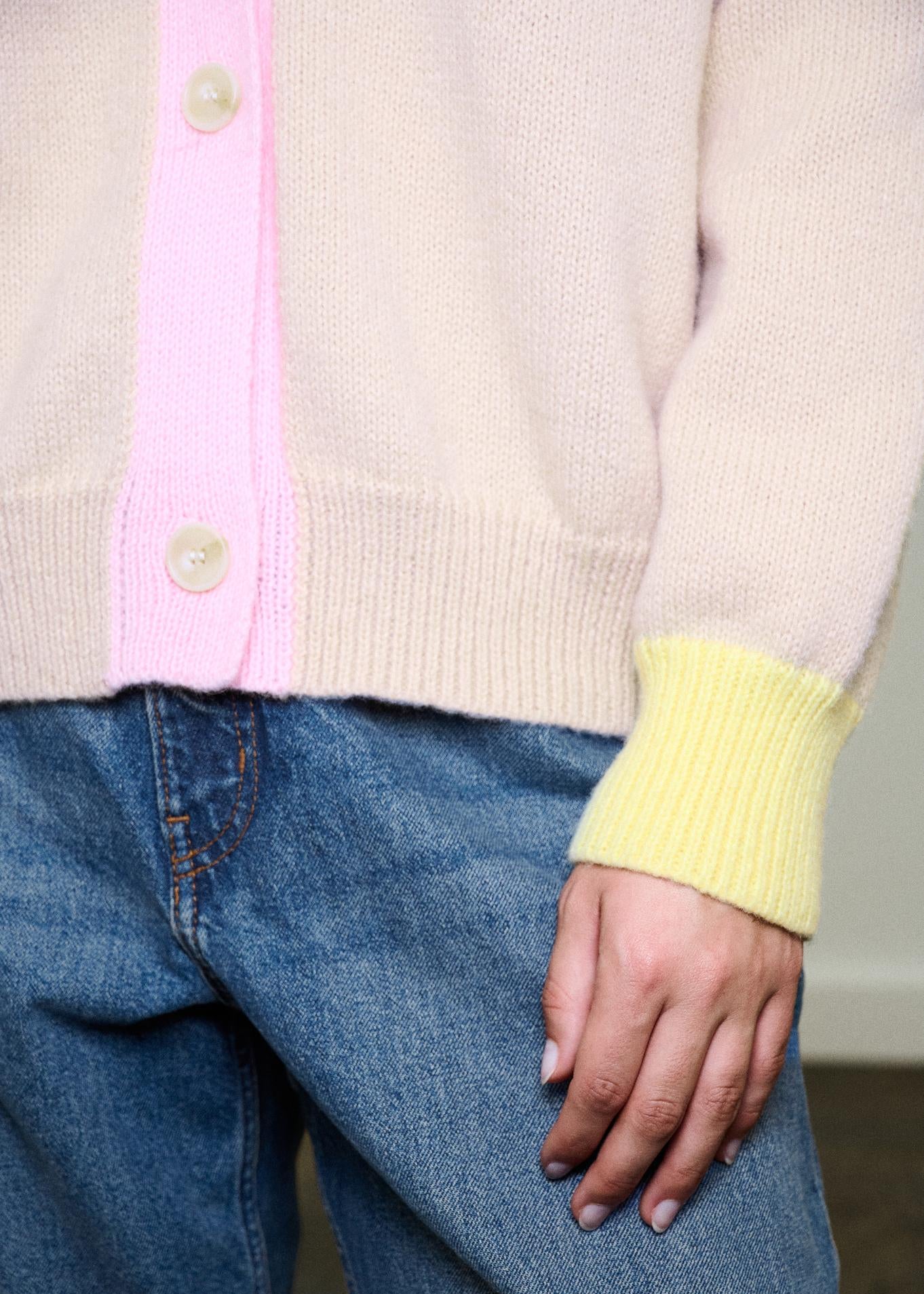 Woman wearing multi colour cardigan on blue background