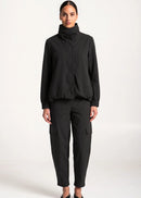 Woman wearing black outfit on white background.