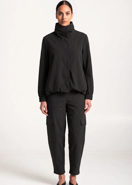 Woman wearing black outfit on white background.