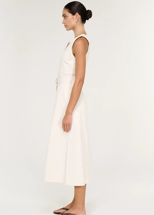 A woman modelling a sleeveless white dress with a keyhole neckline and a matching waist tie belt, photographed against a plain light background.