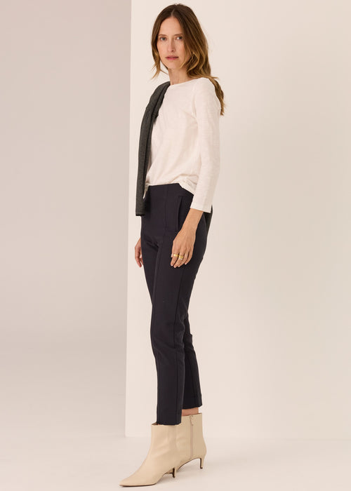 Woman wearing a white top tee on plain background