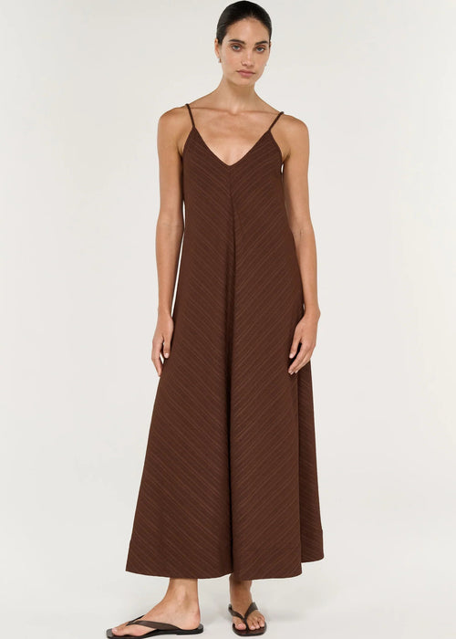 Woman modelling a sleeveless brown maxi dress on grey background