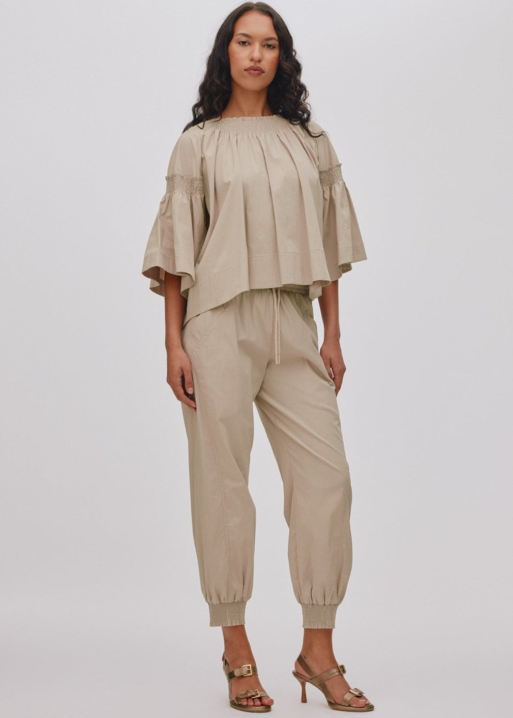 Woman wearing a beige outfit on a white background