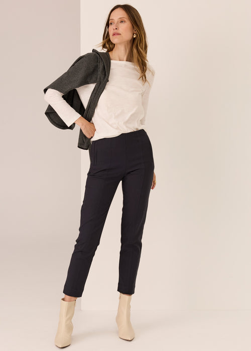 Woman wearing a white top tee on plain background