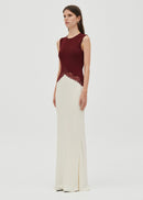 Woman wearing a crimson top and white bottom dress  on grey  background