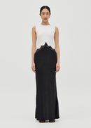 Woman wearing a white sleeveless top and black long skirt dress on a white background

