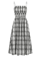 A sleeveless midi dress with thin shoulder straps, a smocked bodice, and a flared skirt in a black and white plaid pattern, shown against a plain white background.