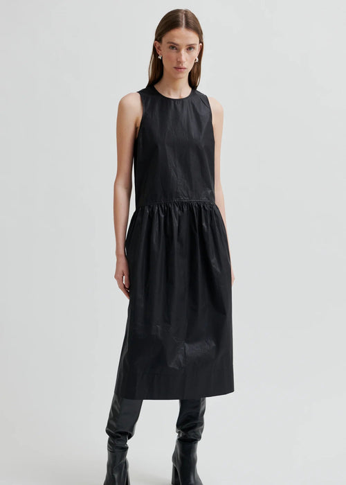 Woman wearing a black sleeveless dress on a white background