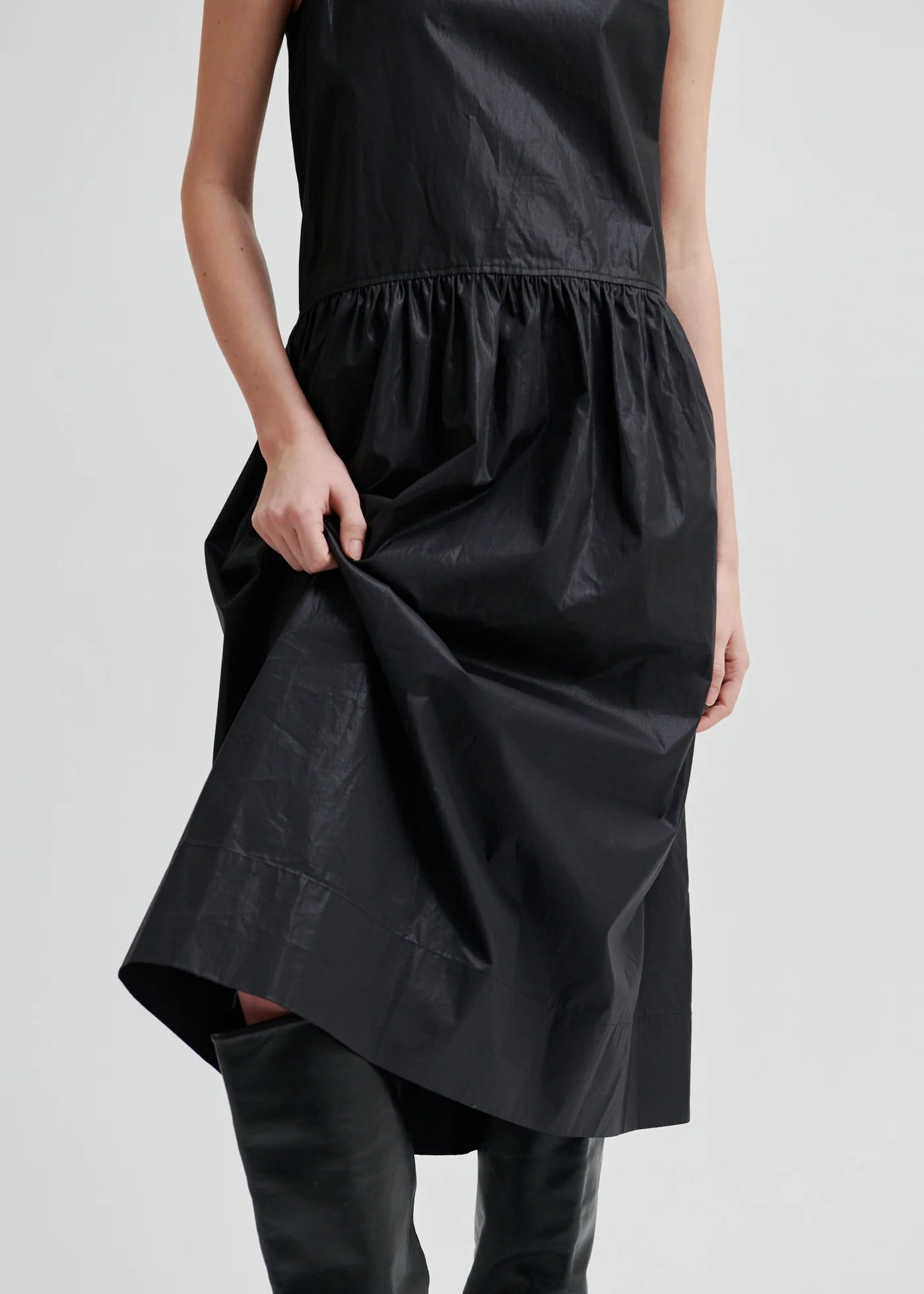 Woman wearing a black sleeveless dress on a white background