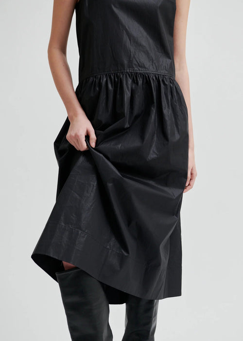 Woman wearing a black sleeveless dress on a white background