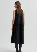Woman wearing a black sleeveless dress on a white background