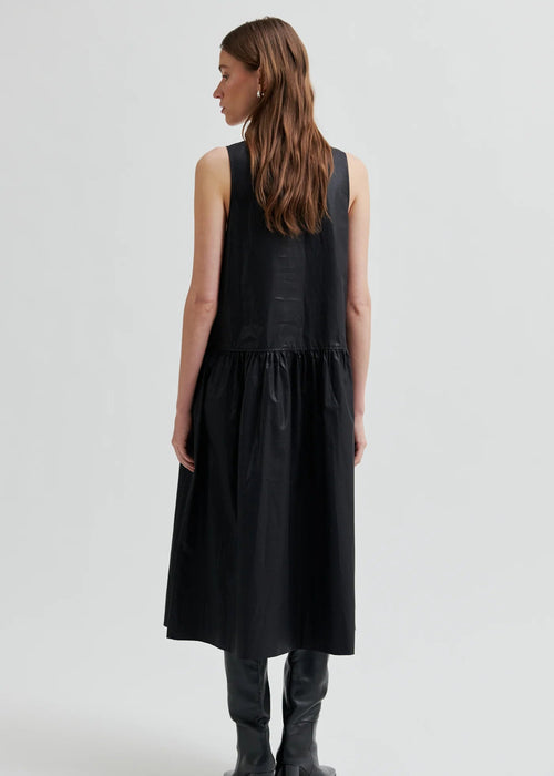 Woman wearing a black sleeveless dress on a white background