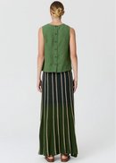 A woman shown from the back wearing a sleeveless green button-front top and a long dark skirt with vertical beige stripes, photographed against a light grey studio background.
