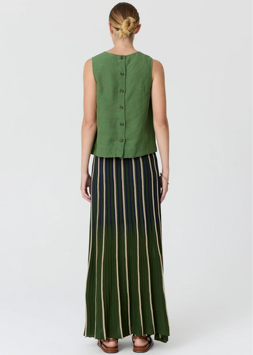 A woman shown from the back wearing a sleeveless green button-front top and a long dark skirt with vertical beige stripes, photographed against a light grey studio background.