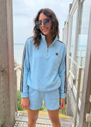 Woman wearing blue sweatshirt with ocean background