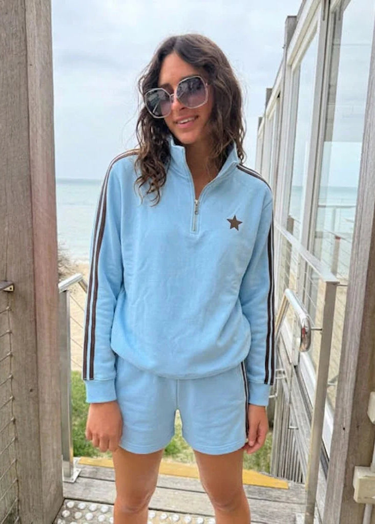 Woman wearing blue sweatshirt with ocean background