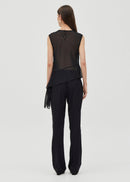 Woman wearing a black sleeveless top and black pants on a white background