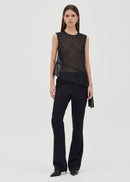 Woman wearing a black sleeveless top and black pants on a white background