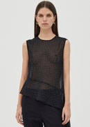 Woman wearing a black polka dot top on a white background