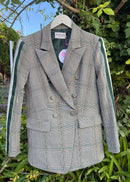Plaid blazer on a hanger against a natural background
