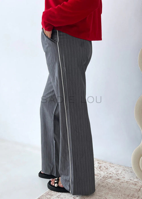Person wearing grey pinstripe pant on white background