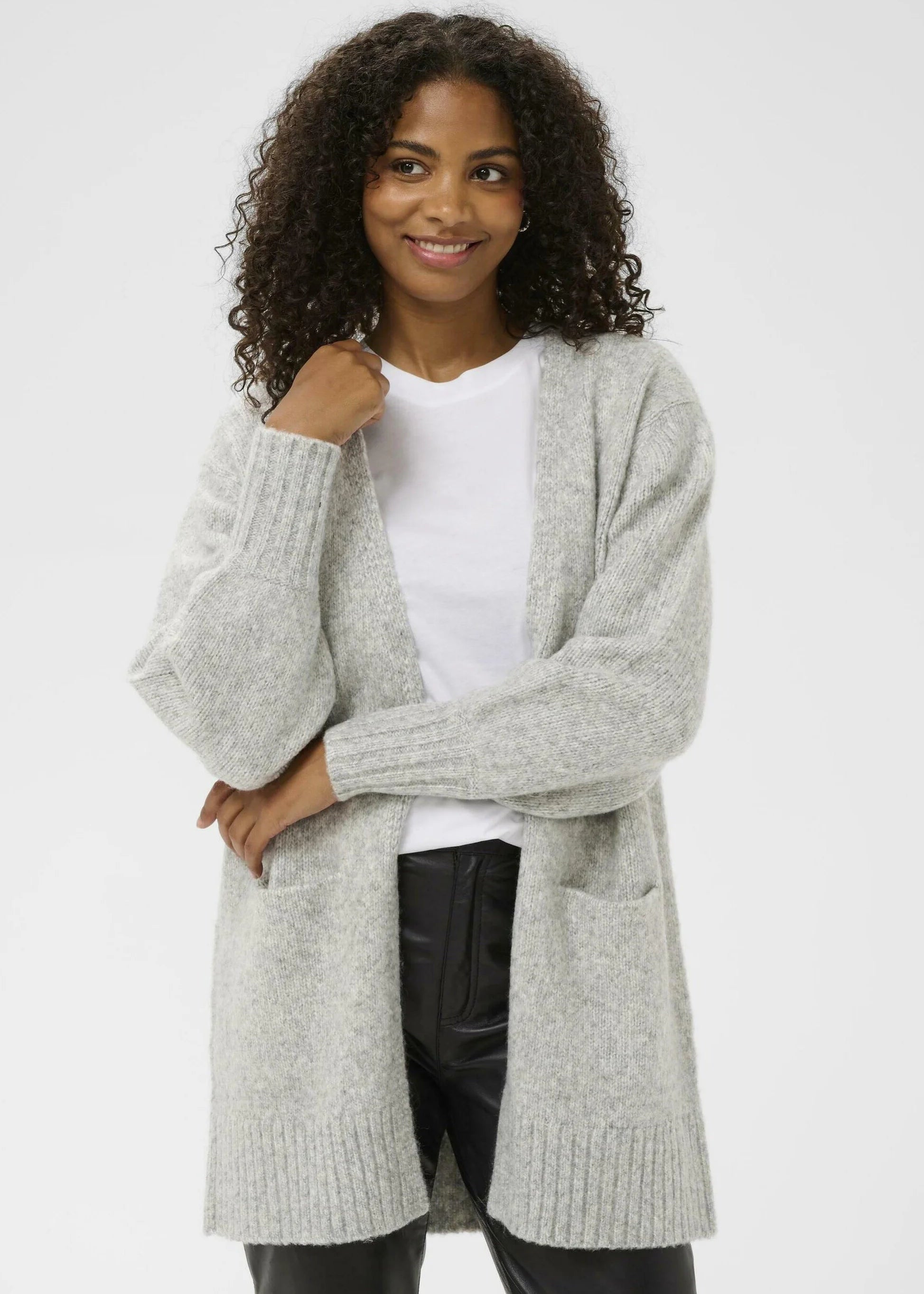 Woman wearing a light grey cardigan over a white shirt on a white background