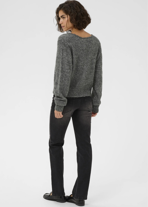 Woman wearing a grey cardigan on a plain background