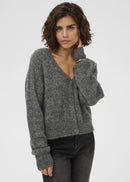 Woman wearing a grey cardigan on a plain background