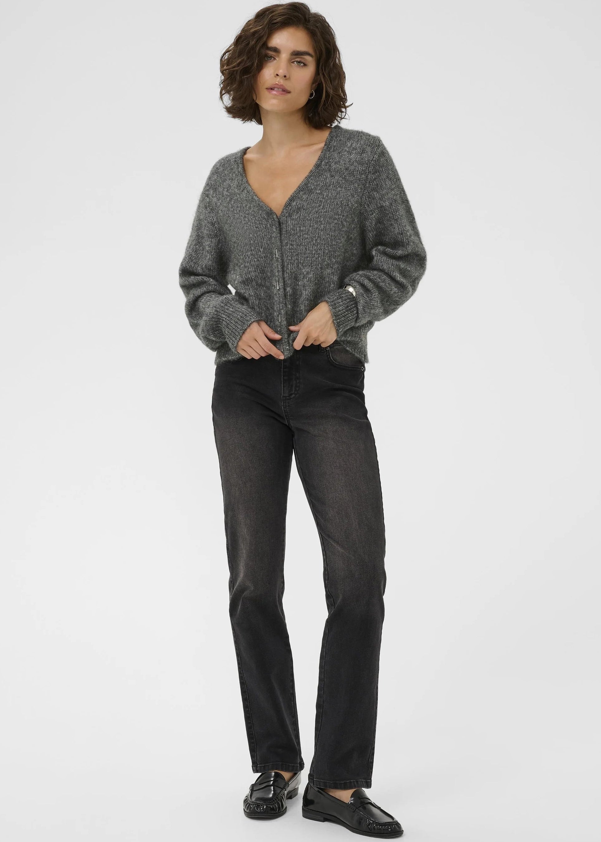 Woman wearing a grey cardigan on a plain background