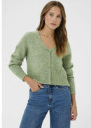 Woman wearing a green cardigan and blue jeans on a white background