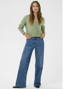 Woman wearing a green cardigan and blue jeans on a white background